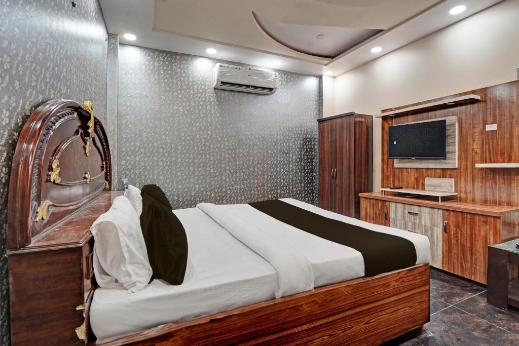 sypialnia z dużym łóżkiem i telewizorem w obiekcie OYO HOTEL MOUNT PALACE w Nowym Delhi