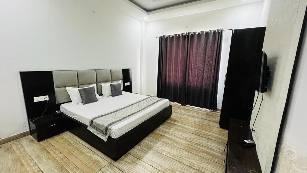 a bedroom with a bed and a flat screen tv at The God's Palace Resort in Meerut