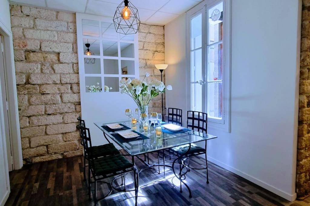 une salle à manger avec une table et des chaises en verre dans l'établissement LE PARC Authentique Coeur de Ville Proximité Parking Climatisé, à Sète
