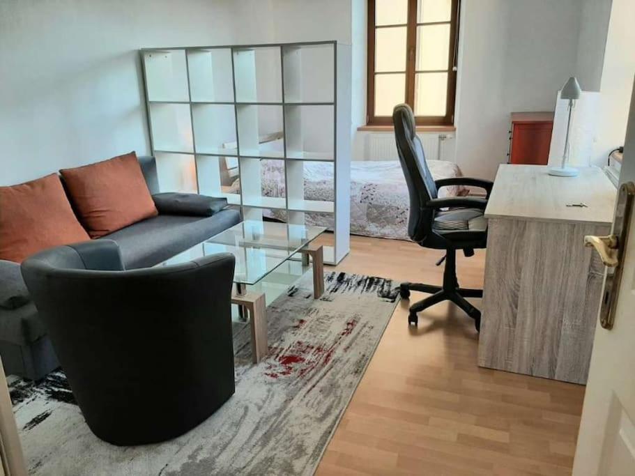 een woonkamer met een bank en een bureau bij Wachau - Angenehm ruhiges Zimmer 5 in Mautern