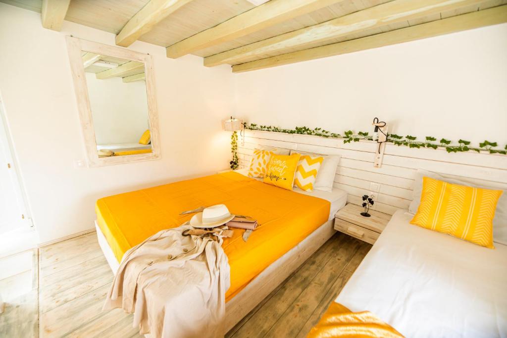 a bedroom with a yellow bed and a mirror at Opus apartment in Agios Stefanos