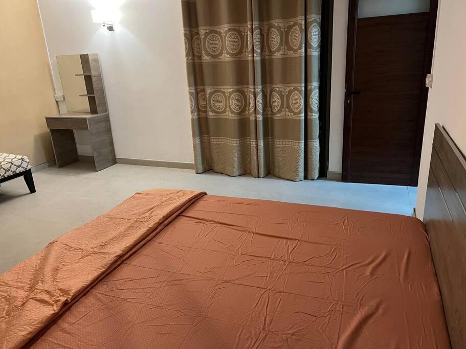 Un dormitorio con una cama con una sábana naranja. en Adorable 2 Bedroom Apartment, en Moka