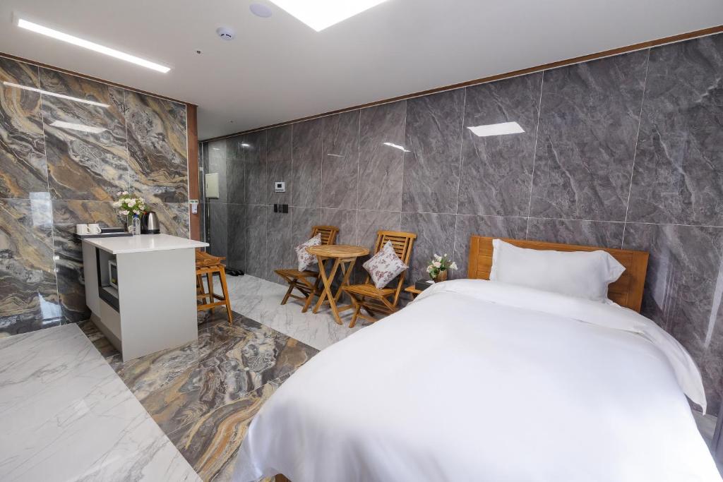 um quarto com uma cama, uma mesa e cadeiras em Central Gwangju Hotel & Residence em Gwangju