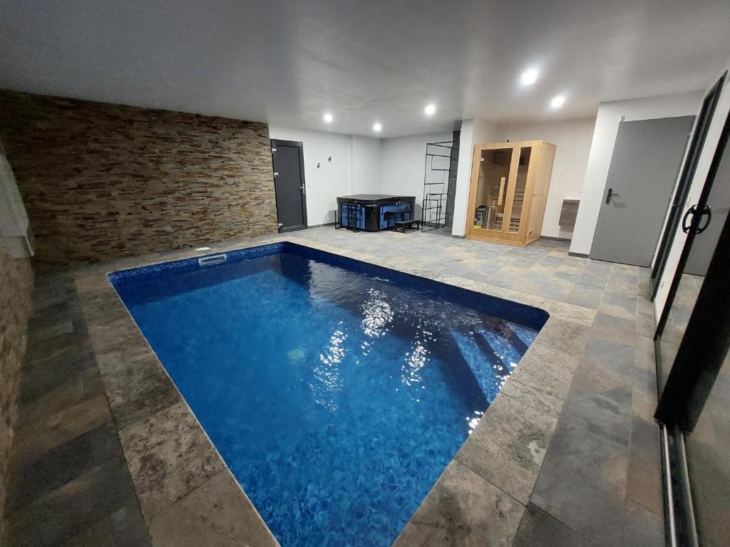 a large swimming pool in a room with a brick wall at Les abeilles du Mont d'or in Manosque