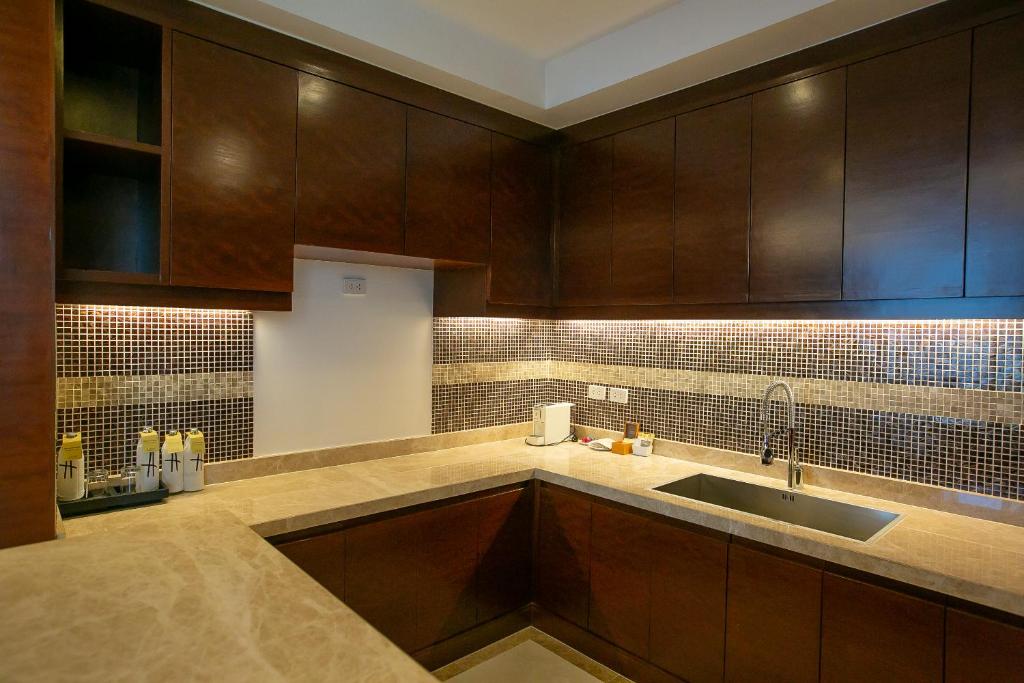A full kitchenette with extensive dark cabinetry and a double-basin sink.