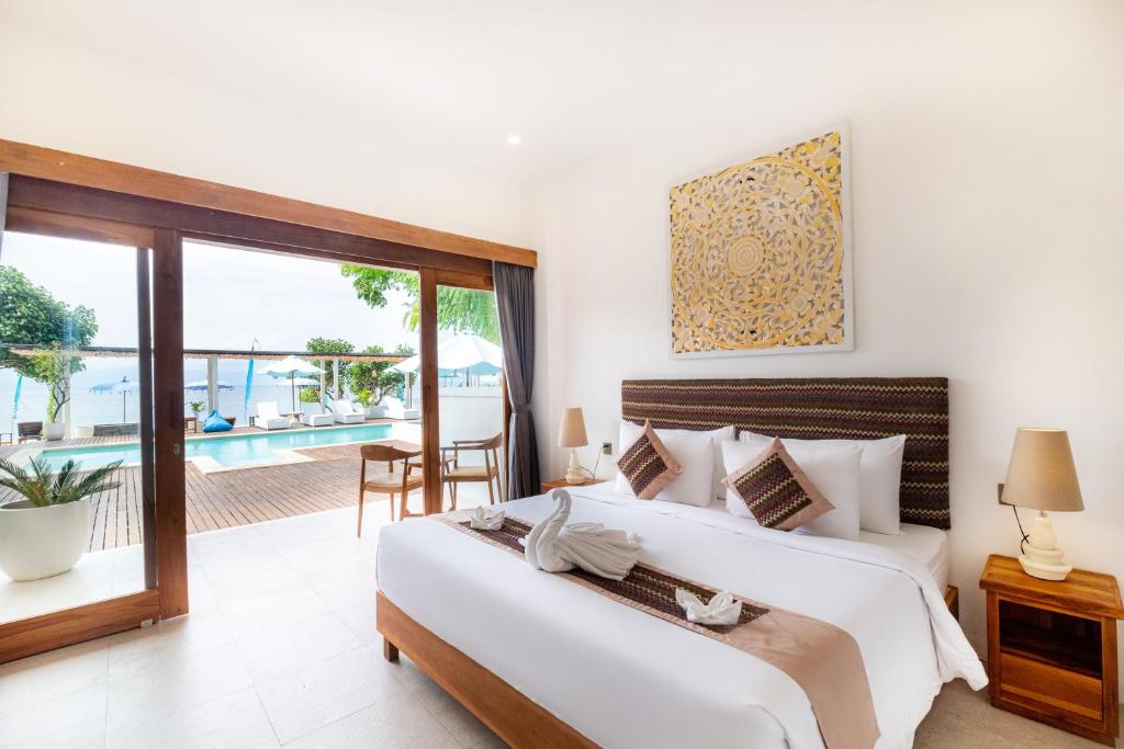 a bedroom with two beds and a view of a pool at AMP Beach House in Nusa Penida