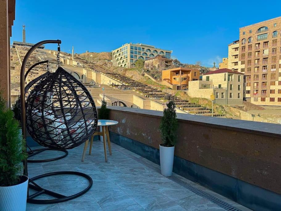 a patio with a table and a chair on a balcony at TOUCH THE SKY Apartment in Yerevan
