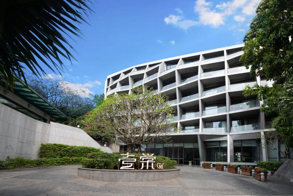 深セン市にあるCM Serviced Apartment Shenzhen Hillsideの看板が目の前にある大きな建物