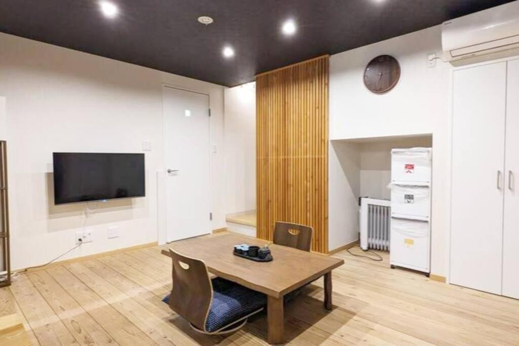 Kyoya Nobuhiro Reisen في كيوتو: غرفة معيشة مع طاولة وتلفزيون