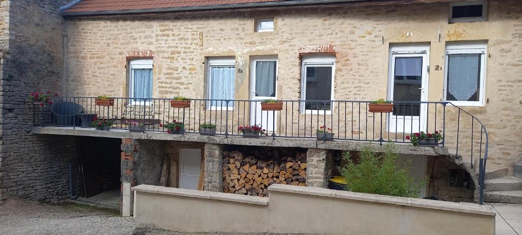 a building with a balcony with potted plants on it at Le cottage du village in Seigny