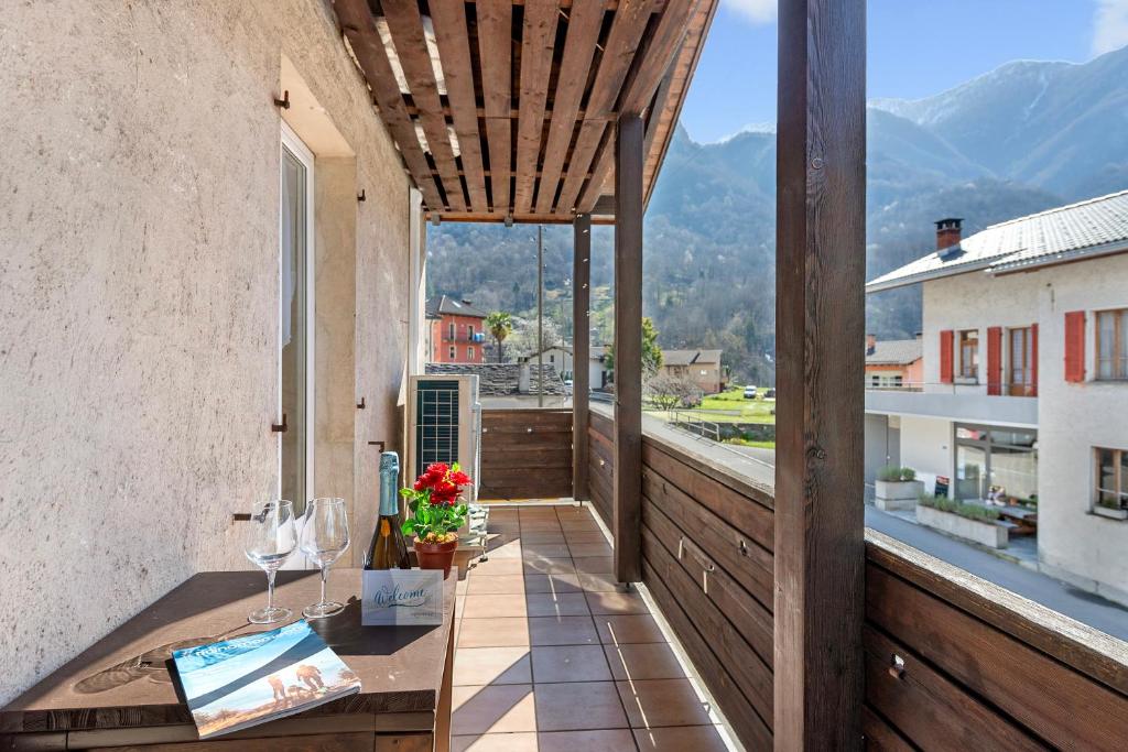 d'un balcon avec des verres à vin et une vue sur les montagnes. dans l'établissement Casa Al Torchio 1,2,3 and 4 - Happy Rentals, à Cavergno