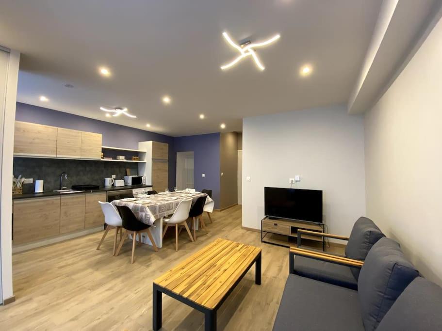 un salon avec une table et une cuisine dans l'établissement Maison en plein centre-ville, à Châteauroux