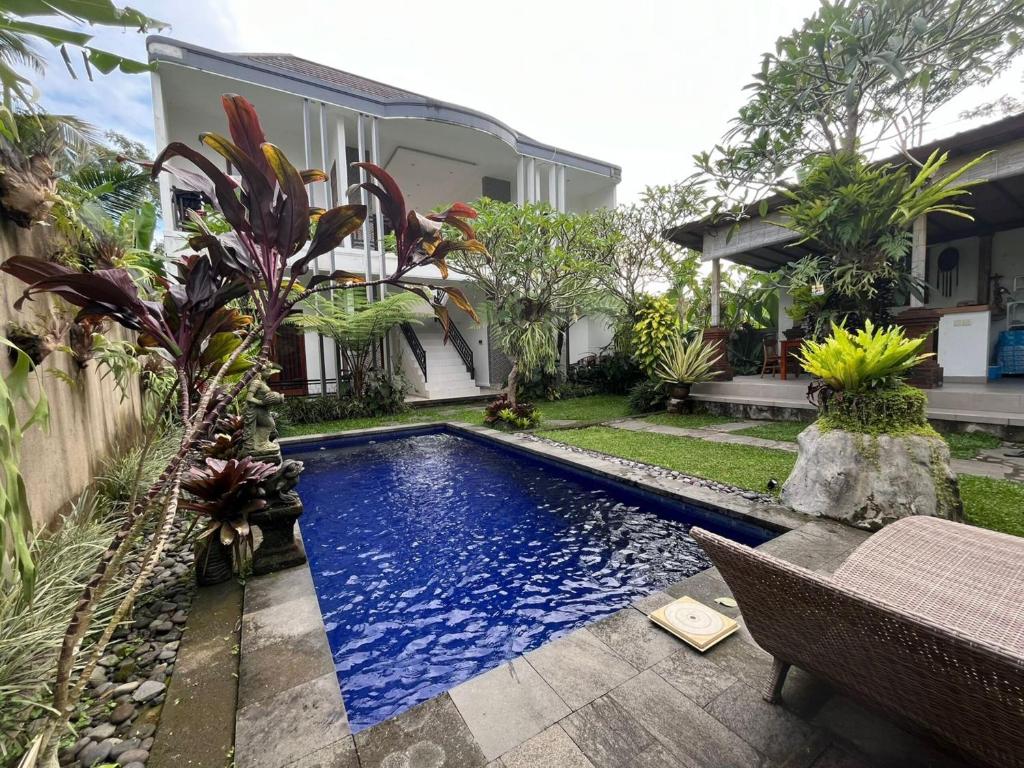 a swimming pool in the yard of a house at Belvilla 93800 The Abhinaya Villa Near Central Ubud in Payangan