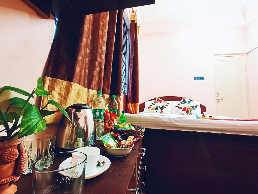Habitación con cama y mesa con planta en The Amber, en Durgāpur