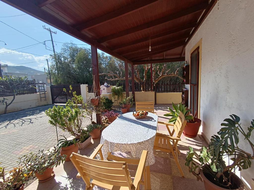 a patio with a table and chairs and potted plants at Golden Horizon Retreat, 2 min walk from the sea! in Gournes
