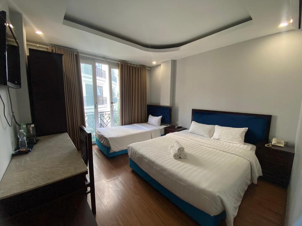 a hotel room with two beds and a television at Mimi Housing in Hanoi