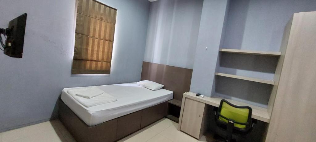 niewielka łazienka z białą umywalką i zielonym krzesłem w obiekcie OYO 93808 Lincoln Dormitory w mieście Tangerang