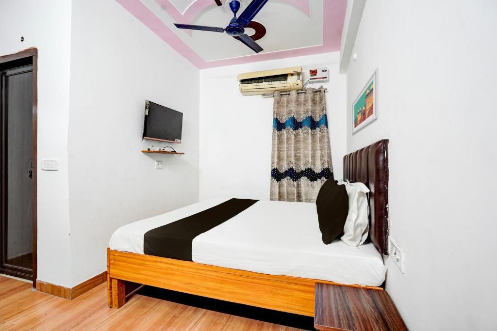 拉姆納格爾的住宿－OYO Premier Jim Corbett Home Stay，一间卧室配有一张床和一台电视。