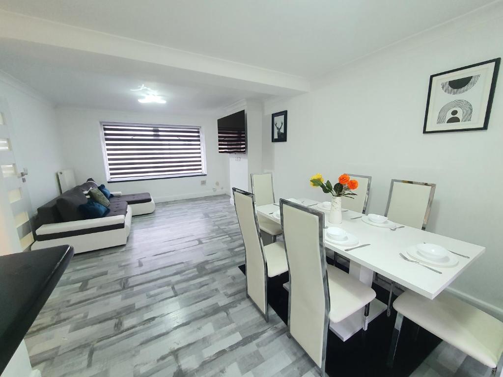 a dining room and living room with a white table and chairs at 1. Single Room (Professional, Trades) Welcome in Luton