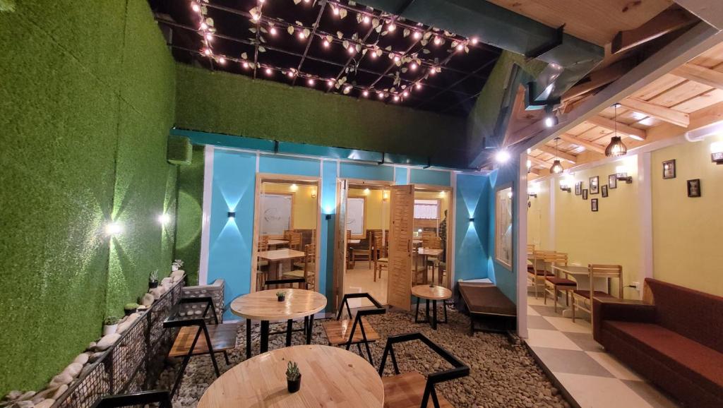 un ristorante con tavoli e sedie e una parete verde di Hotel Hidden Chalet Nainital Near Mall Road - Luxury Room - Excellent Customer Service a Nainital