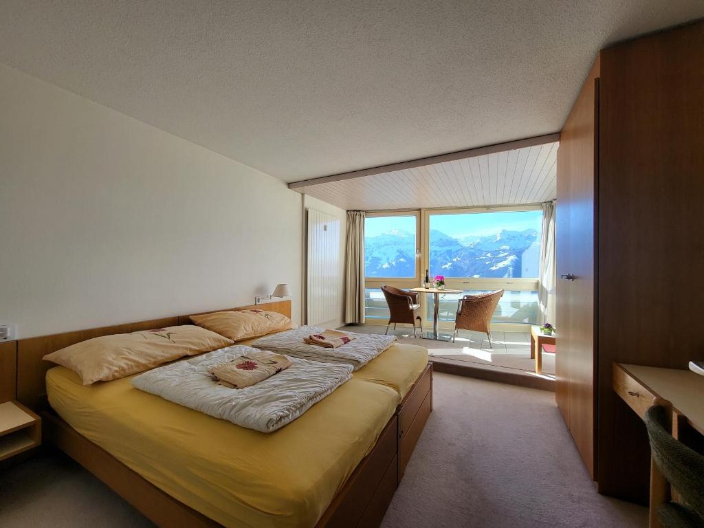 a bedroom with a large bed with a large window at Hotelwohnung Superior-Suite in Beatenberg