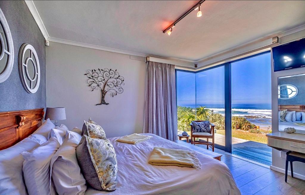 a bedroom with a bed and a view of the ocean at Sawubona Guesthouse in Beach View
