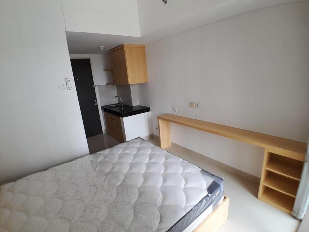 een kleine slaapkamer met een bed en een keuken bij OYO 93826 Cprc Inn Serpong in Tangerang