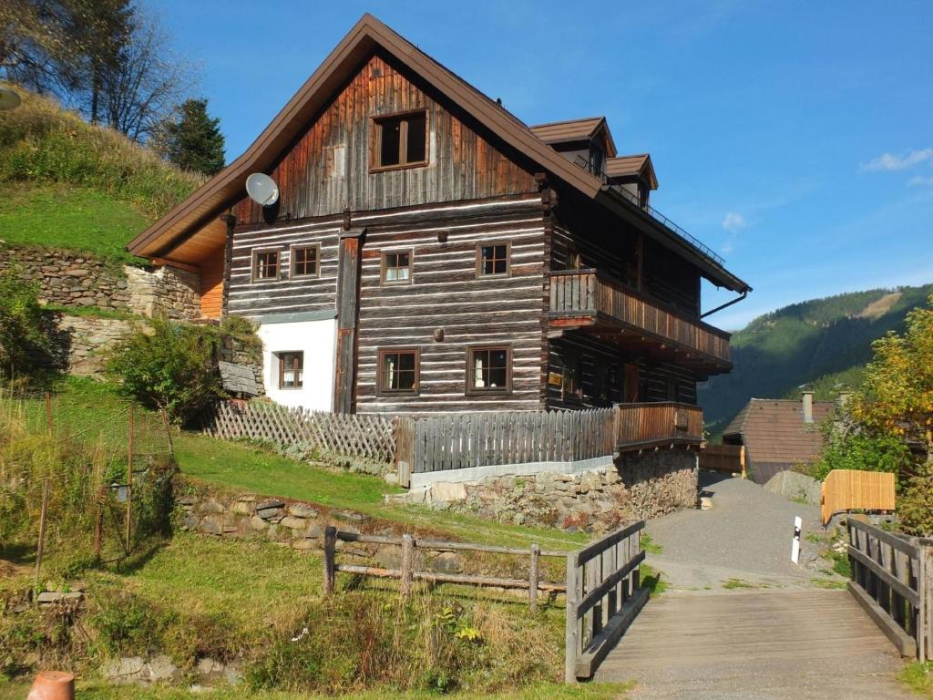 duży drewniany dom na wzgórzu z płotem w obiekcie Nähe Talstation Turracher Höhe, Ferienwohnung in urigem Holzhaus - b60702 w mieście Turracher Hohe