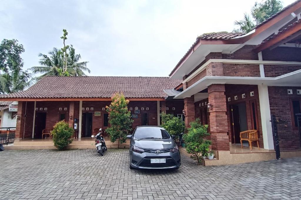 un'auto parcheggiata di fronte a una casa di OYO 93839 Aquenda Homestay a Yogyakarta