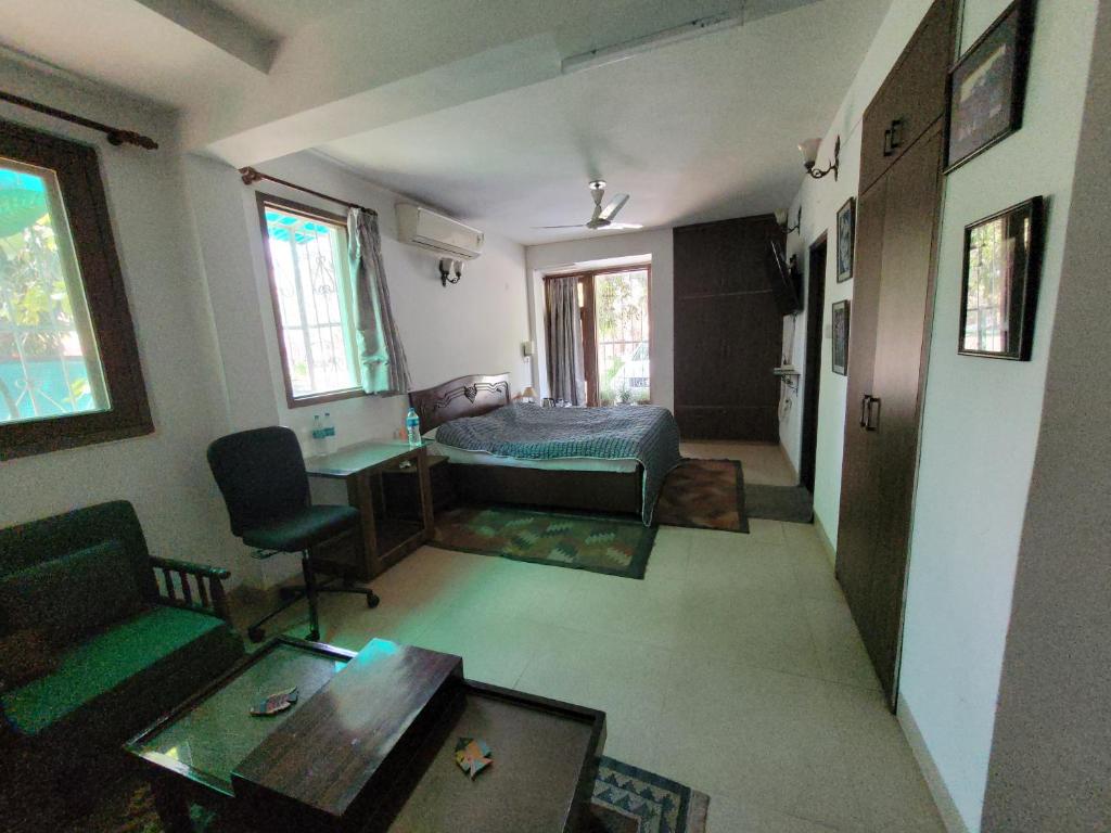Habitación con cama, escritorio y mesa. en Ivy's en Bhopal