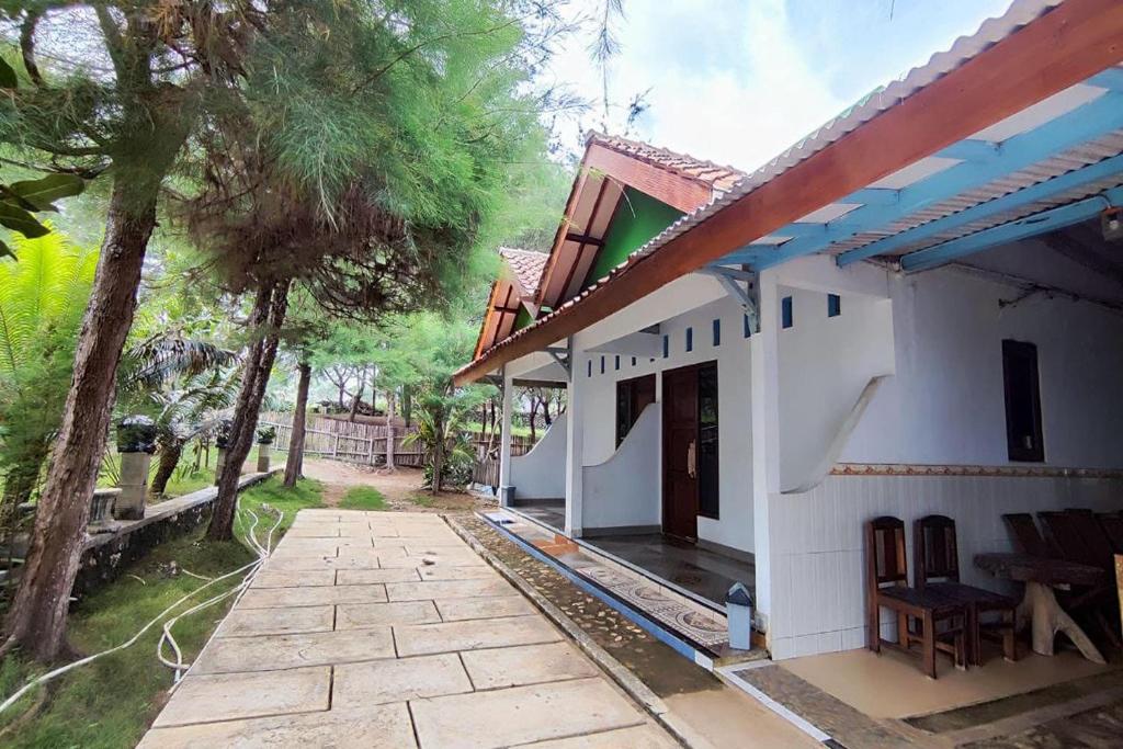 uma casa branca com um alpendre e um pátio em Capital O 93842 Jowo Segoro Resort em Yogyakarta
