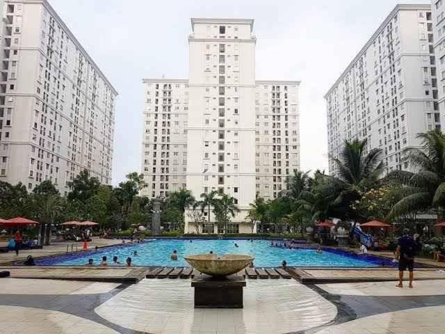 una gran piscina con una fuente frente a edificios altos en OYO 93857 Apartemen Kalibata City By Artomoro, en Yakarta