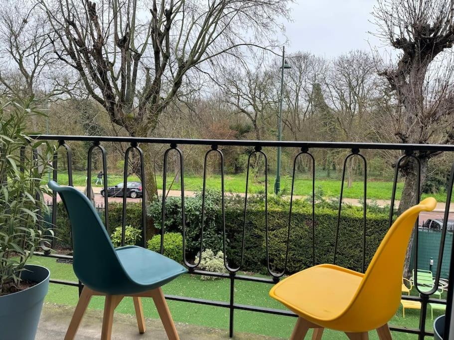 2 chaises assises sur un balcon avec une clôture dans l'établissement Appartement 4P 90 m2 - bois de Vincennes, Paris, à Saint-Maurice