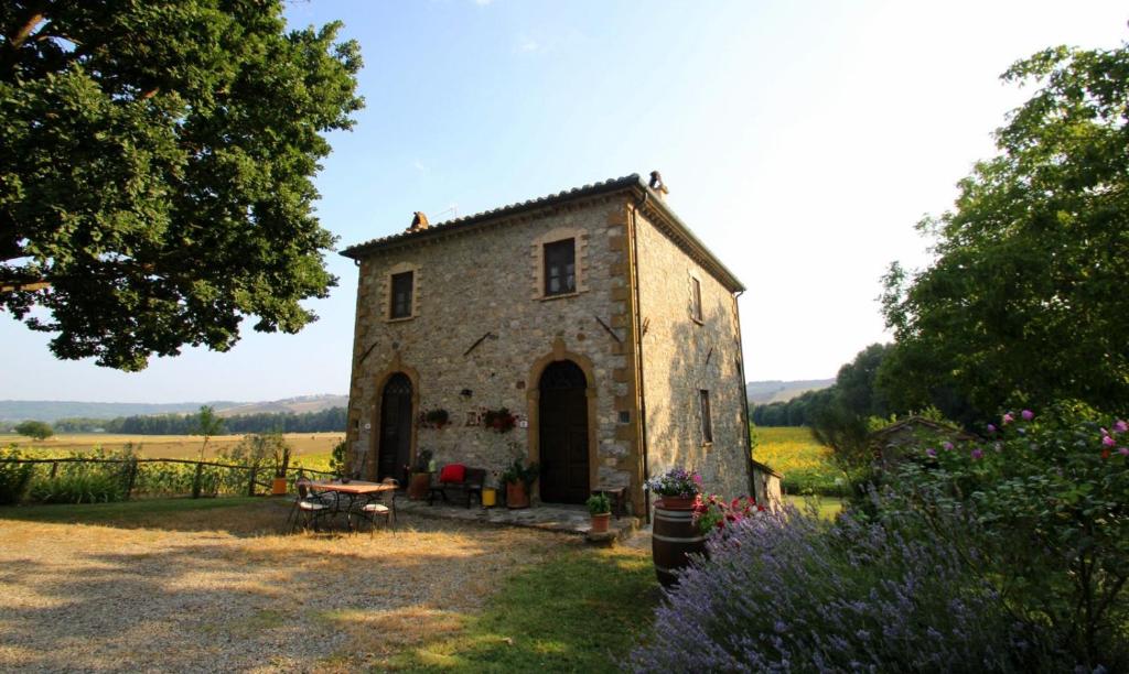 an old stone building in the middle of a field at Agriturismo Le Spighe in Proceno