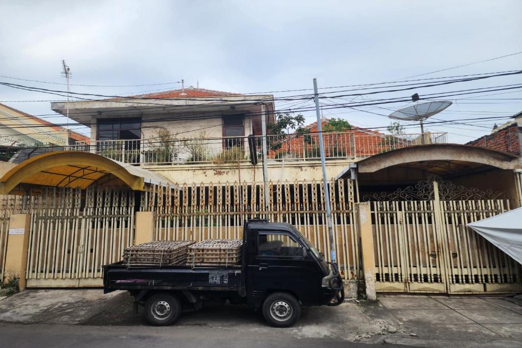 a black truck parked in front of a fence at OYO 93863 Dv Homestay Syariah Genteng in Surabaya