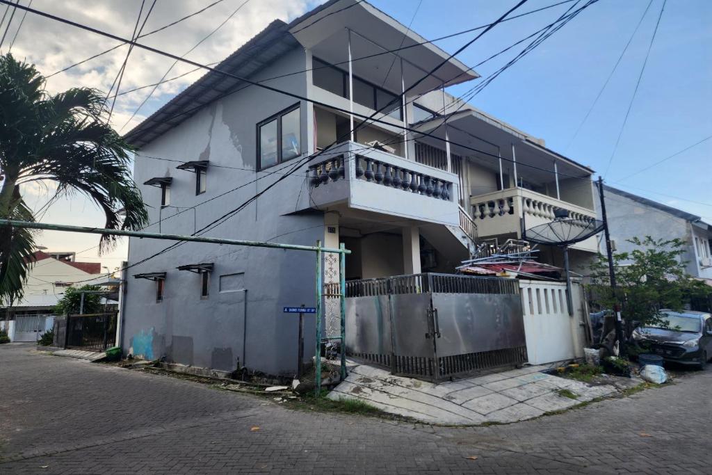 泗水的住宿－OYO 93865 Dv Homestay Syariah Kupang，前面有栅栏的白色房子