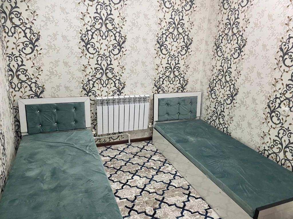 een kamer met 2 bedden en een muur met behang bij Квартира 3-ух Комнатная в центре города in Fergana
