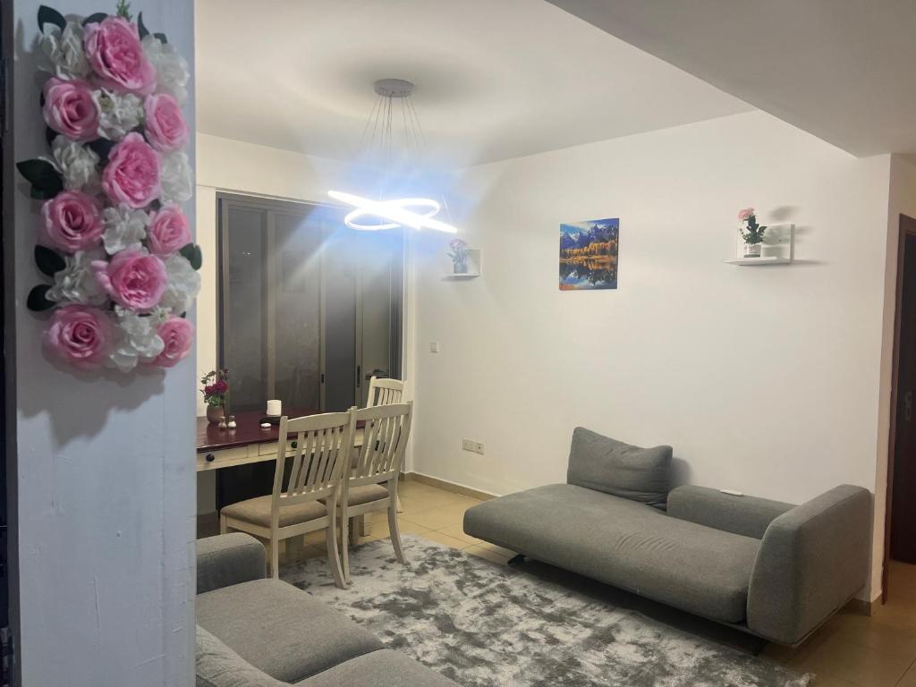 a living room with two couches and a bouquet of pink roses at Hostel Resort VIP in Dubai