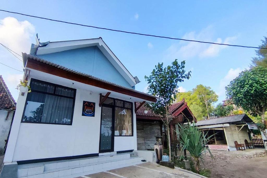 a white house with a red roof at OYO 93867 Minso Inn Sepanjang in Yogyakarta