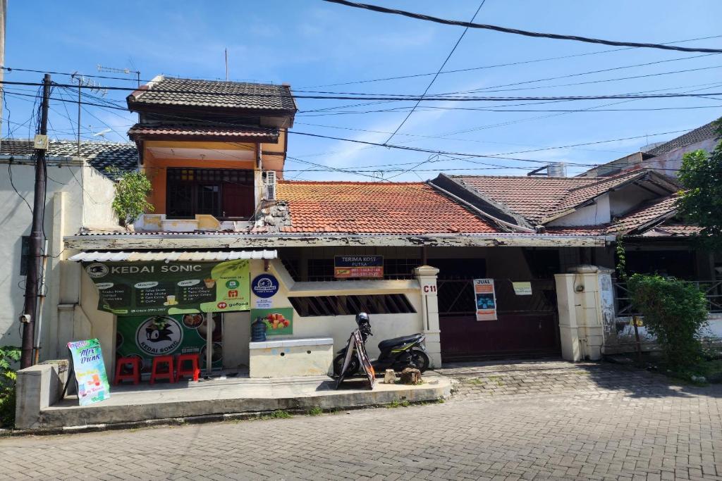 a small building with a store on a street at OYO 93869 Regina Homestay Syariah in Surabaya