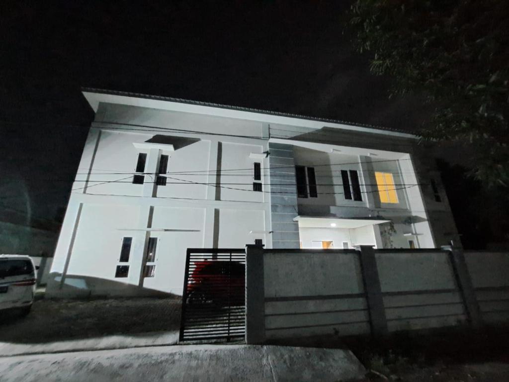 Biały dom z płotem przed nim w obiekcie OYO 93870 Damai Guest House Cirebon w mieście Cirebon