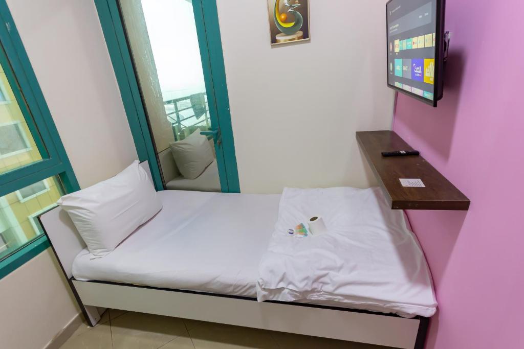 a small bed in a room with a mirror at MC Budget Rooms for Girls Apartment Number 4202 in Dubai