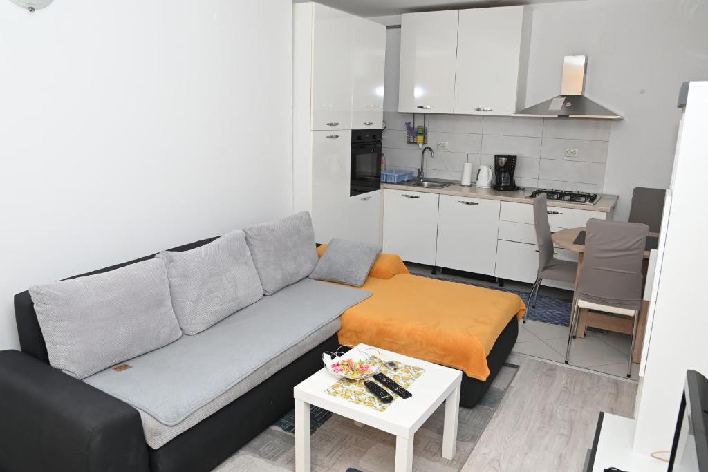 sala de estar con sofá y mesa en Apartment Oscar, en Mokošica