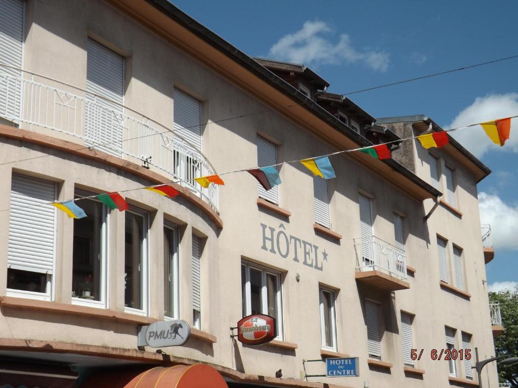 a building with flags hanging in front of it at Hotel Du Centre in Hagondange