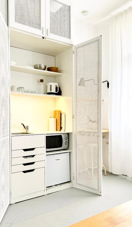a kitchen with white cabinets and a door at Jardin Rooms in Split