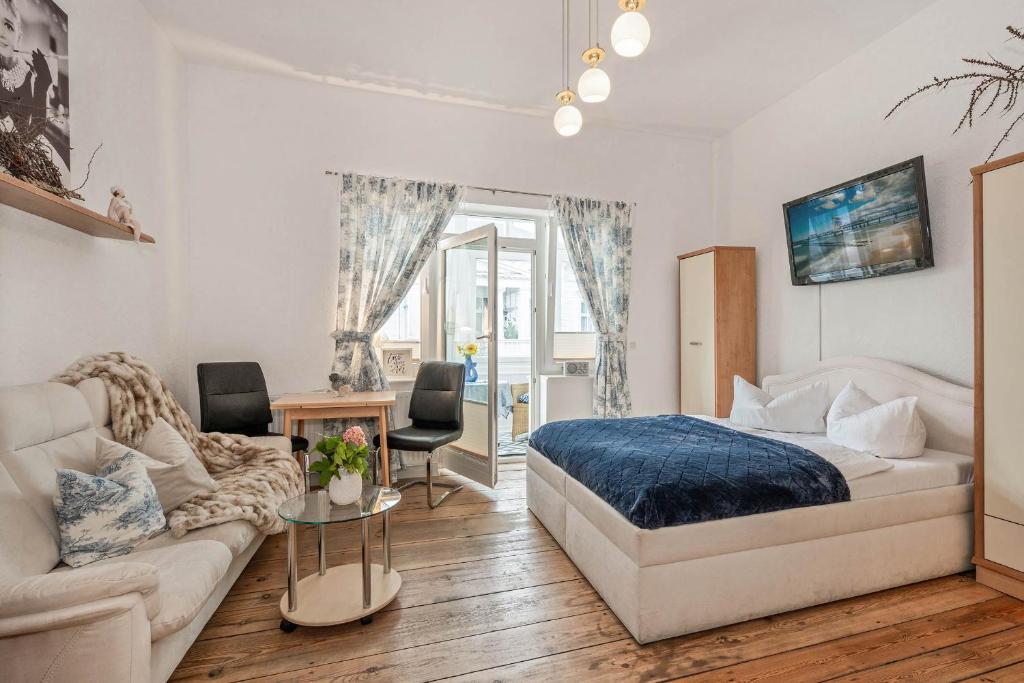 um quarto com uma cama e um sofá em Haus Mertin Whg 2 Seewind em Heringsdorf