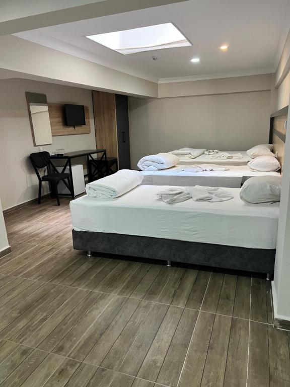 two beds in a room with a table at Marka Hotel in Antalya