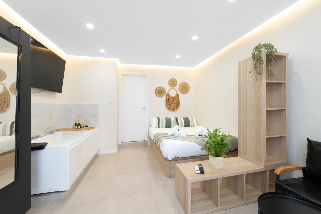a white bedroom with a bed and a fireplace at EXCLUSIVE APARTMENT JACUZZi in Málaga