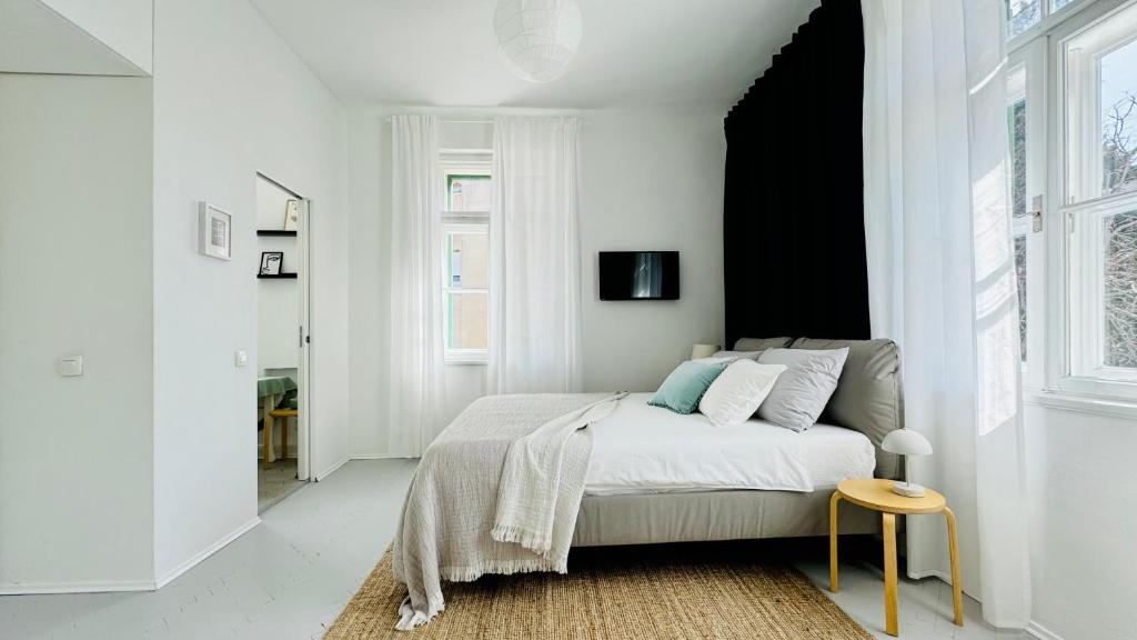 a white bedroom with a bed and a stool at Jardin Rooms in Split
