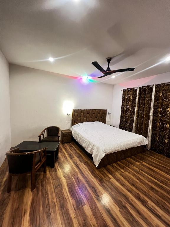 una camera con letto, scrivania e ventilatore a soffitto di Vale of Kashmir Homestay a Srinagar
